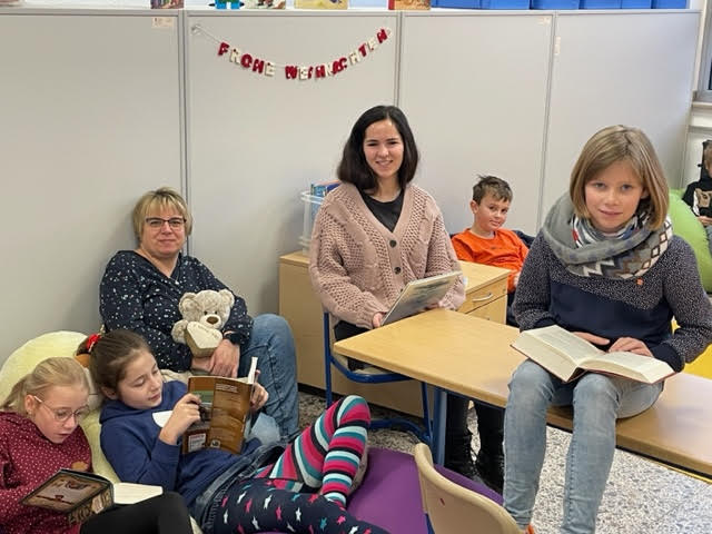 Kinder und Lehrkräfte mit Büchern der Leseinsel